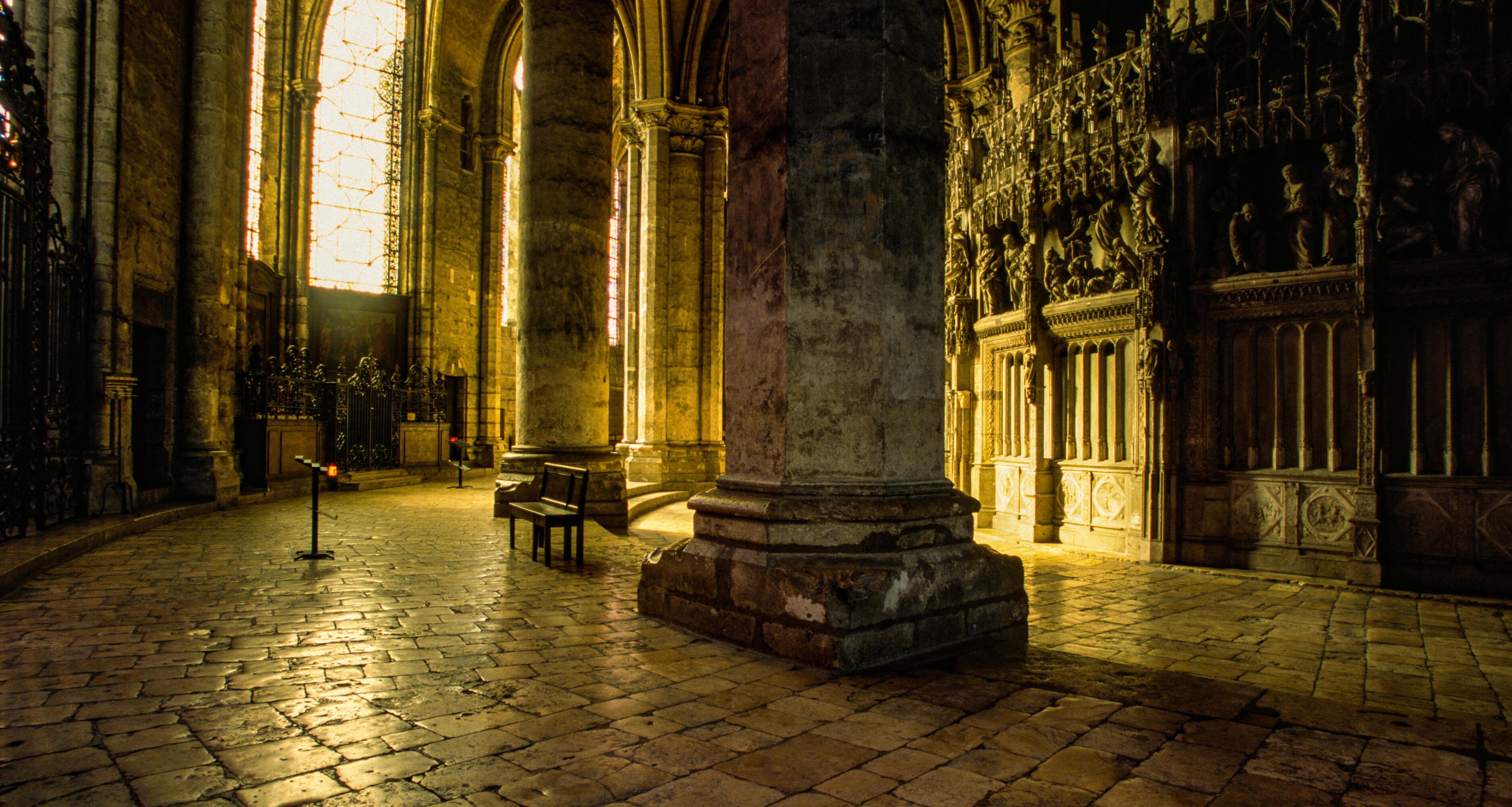 A photograph of the interior of Chartres Cathedral with warm yellow light cast from its windows.